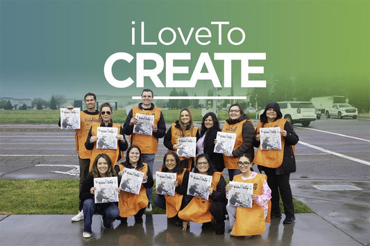 iLoveToCreate logo with image of 12 iLTC team members wearing orange vests and holding kids day newspapers